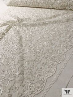 the bed is made with white lace on it