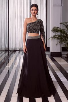 Black one shoulder embroidered blouse with one side split sleeve. Comes with overlap lehenga with embroidered waistband.
Component: 2
Pattern: Embroidered
Type Of Work: Beads
Neckline: Asymmetric
Sleeve Type: One side split sleeve
Fabric: Blouse: Net, Lehenga: Organza
Color: Black
Other Details: 
Embellished split sleeve
Overlap lehenga with embroidered waistband
Occasion: Sangeet - Aza Fashions Lines Embroidery, Blouse With Skirt, Overlap Skirt, Lengha Blouse Designs, Baju Kahwin, Embroidered Beads, Sangeet Outfit, Stylish Kurtis Design, Net Blouse