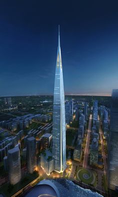 an aerial view of a tall building in the middle of a large city at night