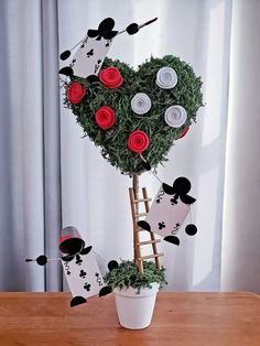 a heart shaped tree made out of paper flowers and other items on a wooden table