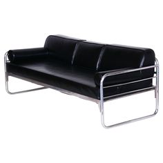 a black leather couch sitting on top of a metal frame