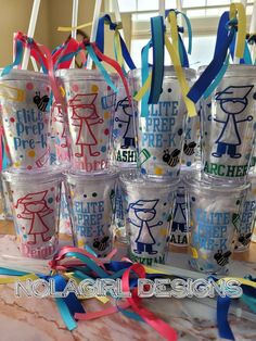 there are many tumblers with different designs on them and ribbons tied around the cups