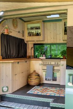 the inside of a small kitchen with wood cabinets and rugs on the floor in front of it