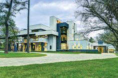 a large white building with lots of windows on it's sides and trees in the front yard