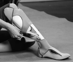 black and white photograph of woman's legs with cutouts on the bottom part of her shoes