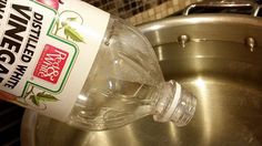 a bottle of vinegar sitting on top of a metal bowl