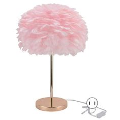 a pink feather lamp on a stand with an outlet for the plugged in charger