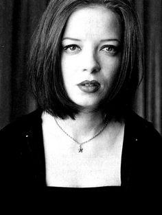 a black and white photo of a woman wearing a necklace with a cross on it