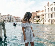 a woman standing on the edge of a boat in venice