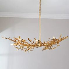 a gold chandelier hanging from a ceiling in a room with white walls and flooring