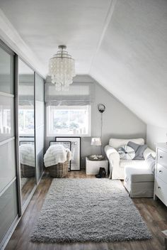 an attic bedroom with white furniture and gray carpet