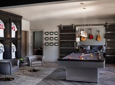 a living room with a pool table, chairs and other items on the shelves in front of it