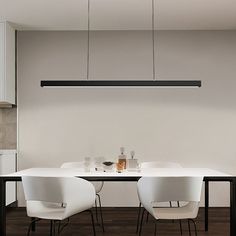 a dining room table with four chairs and a light hanging from the ceiling over it