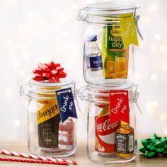 three glass jars filled with different types of condiments next to candy canes