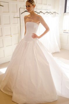 a woman in a white wedding dress posing for the camera