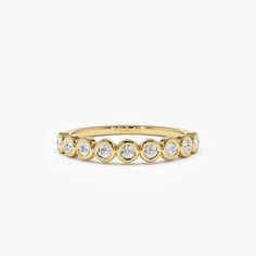 a yellow gold ring with five round diamonds