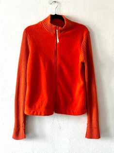 Soft & stretchy orange fuzzy fleece jacket with a full zip, pockets, and elastic ribbing on the sleeves and collar. Some minor pilling + a small stain on the back of the right sleeve (see photos) - sold as is. DETAILSLabel: Express JeansMade in Taiwan R.O.C. Body Material: 100% Polyester Trim: 100% Acrylic SIZE & MEASUREMENTSTag Size: Large Best Fits: Small Length: 26"Bust: 37"Waist: 36"Sleeve: 29"Shoulder: 17" Cheap Orange Outerwear With Button Closure, Express Jeans, Dress Suits, Zip Up, Fleece Jacket, Taiwan, Zip Pockets, Zip Ups, Shopping Outfit