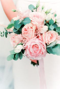 a bride holding a bouquet of pink flowers