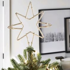 a small christmas tree with lights on it and a star decoration hanging from the top