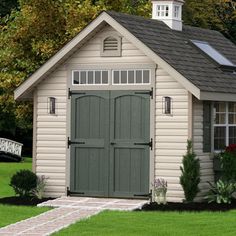 a small shed with a clock tower on the top of it's roof and windows