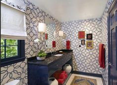 a bathroom with blue and white wallpaper, two sinks and a rug on the floor