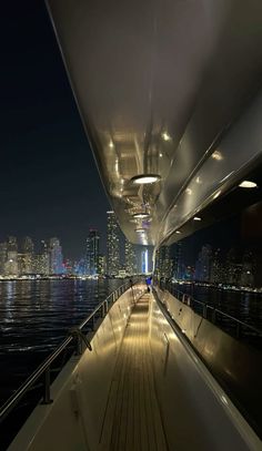 the deck of a boat at night with city lights