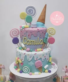 there is a colorful cake with candy on the top and an ice cream cone in the middle