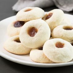 small cookies with jam are on a white plate