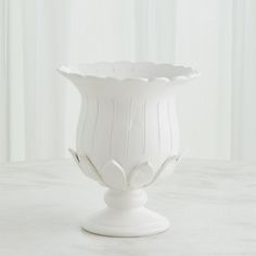 a white vase sitting on top of a table