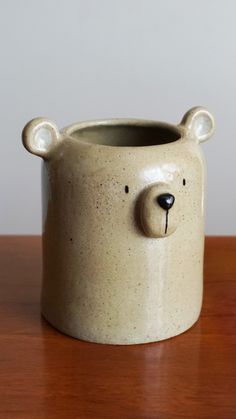 a ceramic bear mug sitting on top of a wooden table