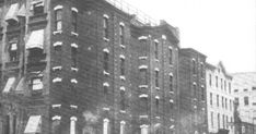 an old black and white photo of a building with fire escapes on the top floor