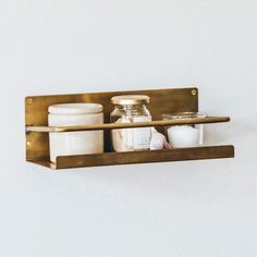 two wooden shelves with jars and containers on them