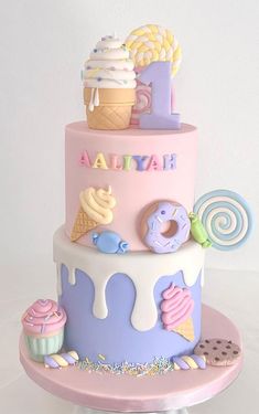 a three tiered cake with ice cream, doughnuts and candies on it