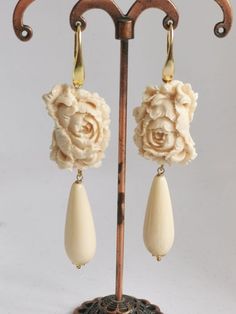 Dangling earrings with imitation ivory paste drops and cameo flowers in handmade ivory paste at Torre del Greco depicting flowers, 2.5 cm in size, closing to silver monachelle 925. 8 cm total length. Elegant Beige Flower Earrings For Gift, Elegant Beige Flower Earrings Gift, Elegant Cream Flower Earrings, Elegant Cream Flower Earrings For Gift, Elegant Carved Flower Jewelry, Elegant Beige Teardrop Earrings, Red Coral Earrings, Red Coral Necklace, Drop Earrings Silver