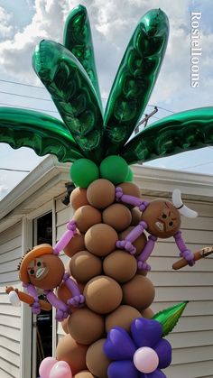 an inflatable palm tree with balloons attached to it