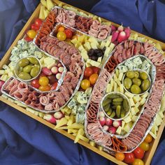 a number shaped tray filled with different types of food and olives on top of it