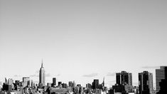 a black and white photo of a city skyline with the empire building in the background