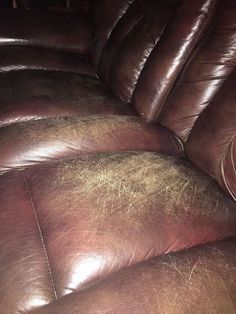 a brown leather couch with lots of dirt on the top and bottom of it's back