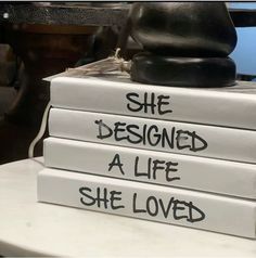 three books stacked on top of each other with the words she designed a life she loved