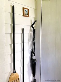 two brooms are hanging on the wall next to each other