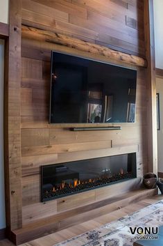 a large television mounted to the side of a wall above a fire place in a living room