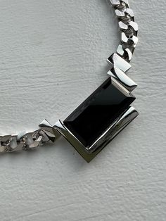 "1980s silver chrome chain necklace with rectangular black onyx detail. very rare piece by Kunio Matsumoto for Trifari. a bold piece, yet, timeless and very versatile. One of those that will always be in style. an incredible find and stunningly crafted - in excellent condition. measurements: total length, closed, measured inside: 16 1/2\" inches width of chain: a little over 1/4\" inch size of onyx framed center piece:  about 2 1/2\" inches wide and 1 1/4\" inch height - whole piece, frame & sto Modern Black Formal Chain Necklace, Modern Black Chain Necklace For Formal Occasions, Elegant Silver Chain Necklace With Rectangular Pendant, Modern Silver Necklace With Rectangular Stone, Modern Necklace With Silver Chain And Rectangular Pendant, Black Rectangular Chain Necklace, Elegant Black Jewelry With Rectangular Links, Modern Silver Necklace For Evening, Modern Jewelry With Rectangular Pendant And Silver Chain