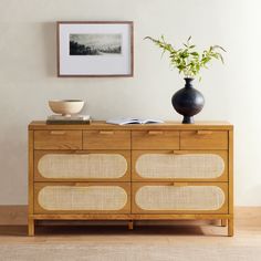 a wooden dresser with two vases on top of it