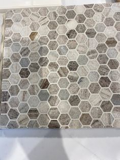 a marble counter top with hexagonal tiles on the bottom and one tile in the middle