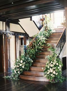 the stairs are decorated with flowers and greenery