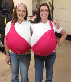 two pregnant women standing next to each other with their hands on their hipss, both wearing pink and white shirts