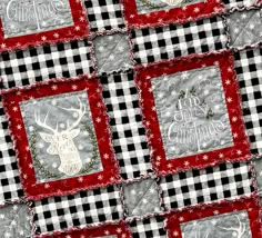 a close up of a quilt on a table cloth with reindeers and snowflakes