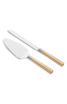 two white and gold serving utensils next to each other