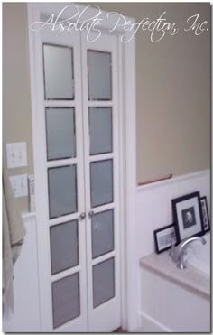 an empty bathroom with white walls and glass doors