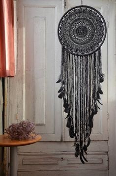 a black and white dream catcher hanging from a door